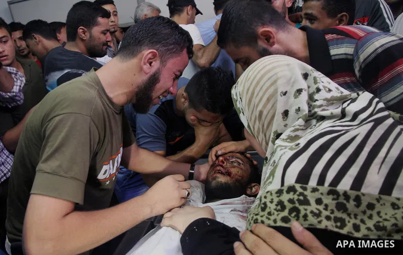 Palestinians mourn over the body of his relative Rami Abu Nahel, killed in an Israeli military strike, at Gaza city's Al-Shifa hospital on August 21, 2014. Three senior Hamas commanders and four children were among at le...