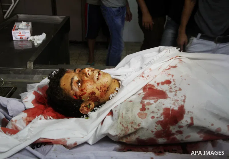 Palestinians mourn over the body of his relative Mohammed Abu Nahel, killed in an Israeli military strike, at Gaza city's Al-Shifa hospital on August 21, 2014. Three senior Hamas commanders and four children were among a...