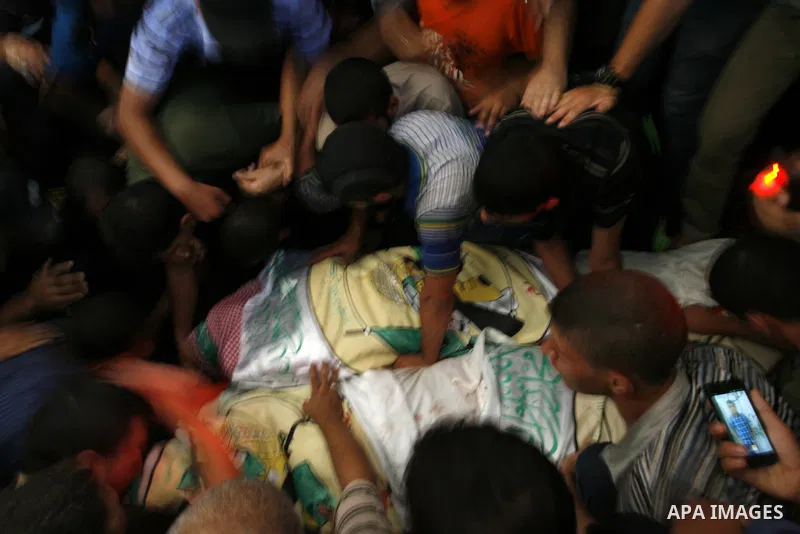 Palestinian mourners carry the bodies of three senior Hamas commanders during their funeral in the southern Gaza Strip town of Rafah on August 21,2014. Israeli warplanes killed three top Hamas commanders in southern Gaza...