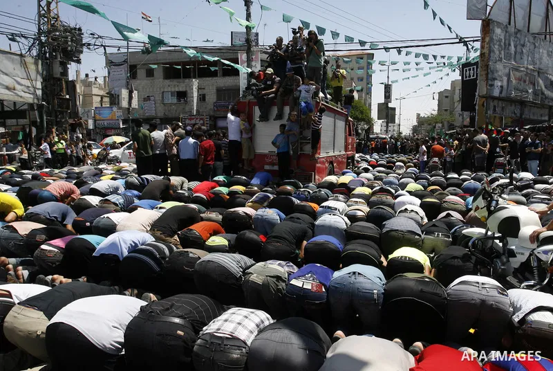 Palestinian mourners pray on the bodies of three senior Hamas commanders during their funeral in the southern Gaza Strip town of Rafah on August 21,2014. Israeli warplanes killed three top Hamas commanders in southern Ga...