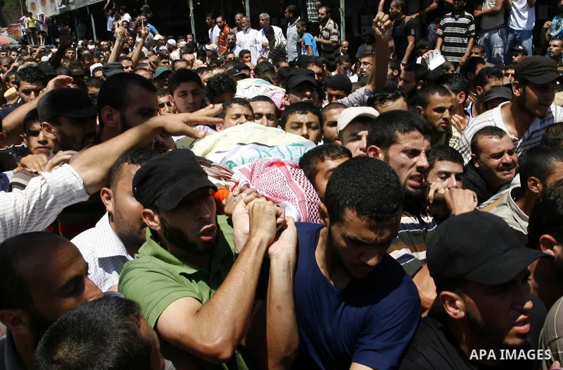 Palestinian mourners carry the bodies of three senior Hamas commanders during their funeral in the southern Gaza Strip town of Rafah on August 21,2014. Israeli warplanes killed three top Hamas commanders in southern Gaza...