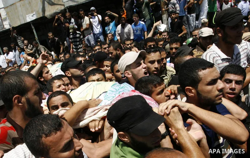 Palestinian mourners carry the bodies of three senior Hamas commanders during their funeral in the southern Gaza Strip town of Rafah on August 21,2014. Israeli warplanes killed three top Hamas commanders in southern Gaza...