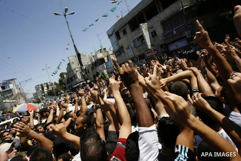 Palestinian mourners carry the bodies of three senior Hamas commanders during their funeral in the southern Gaza Strip town of Rafah on August 21,2014. Israeli warplanes killed three top Hamas commanders in southern Gaza...