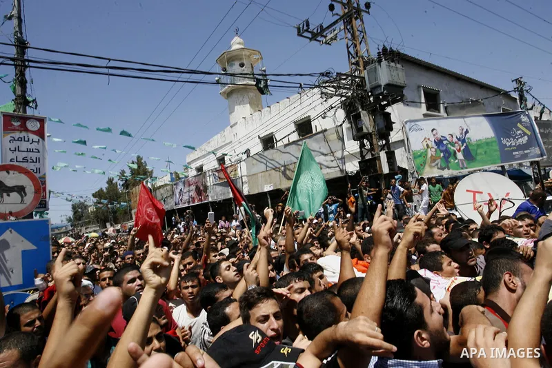 Palestinian mourners carry the bodies of three senior Hamas commanders during their funeral in the southern Gaza Strip town of Rafah on August 21,2014. Israeli warplanes killed three top Hamas commanders in southern Gaza...