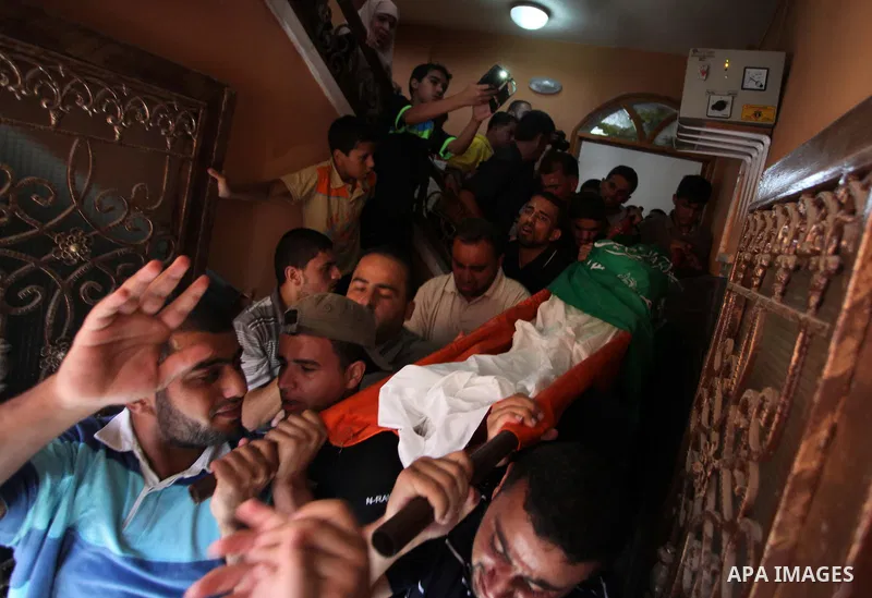 Palestinian mourners carry the body Mohammed Barhoum, one of three senior Hamas commanders who was killed in an Israeli air strike, mourn during his funeral in Rafah in the southern Gaza Strip August 21, 2014. Israel kil...