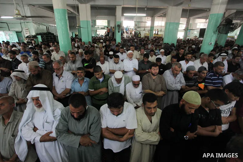 Palestinian mourners pray on the bodies of three senior Hamas commanders during their funeral in the southern Gaza Strip town of Rafah on August 21,2014. Israel killed three senior Hamas commanders in an air strike on th...