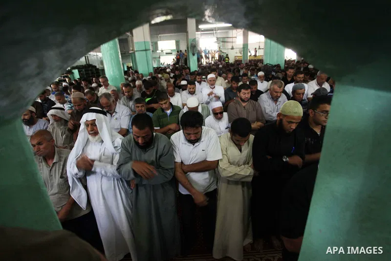 Palestinian mourners pray on the bodies of three senior Hamas commanders during their funeral in the southern Gaza Strip town of Rafah on August 21,2014. Israel killed three senior Hamas commanders in an air strike on th...
