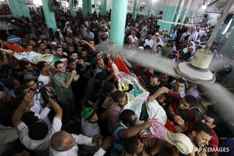 Palestinians carry the bodies of three senior Hamas commanders, who were killed in an Israeli air strike, during their funeral in Rafah in the southern Gaza Strip August 21, 2014. Israel killed three senior Hamas command...