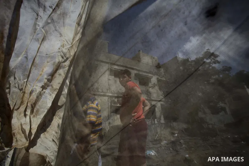 Palestinians gather around the remains of a house, which witnesses said was destroyed in an Israeli air strike, in Gaza City August 22, 2014. Since the collapse on Tuesday of a 10-day ceasefire, the Israeli military has...
