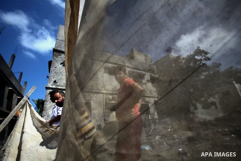 Palestinians gather around the remains of a house, which witnesses said was destroyed in an Israeli air strike, in Gaza City August 22, 2014. Since the collapse on Tuesday of a 10-day ceasefire, the Israeli military has...