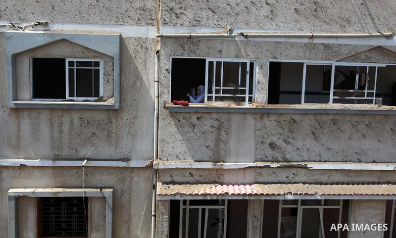 A Palestinian woman cleans the edge of her house's window, which witnesses said was damaged in an Israeli air strike, in Gaza City August 22, 2014. Since the collapse on Tuesday of a 10-day ceasefire, the Israeli militar...
