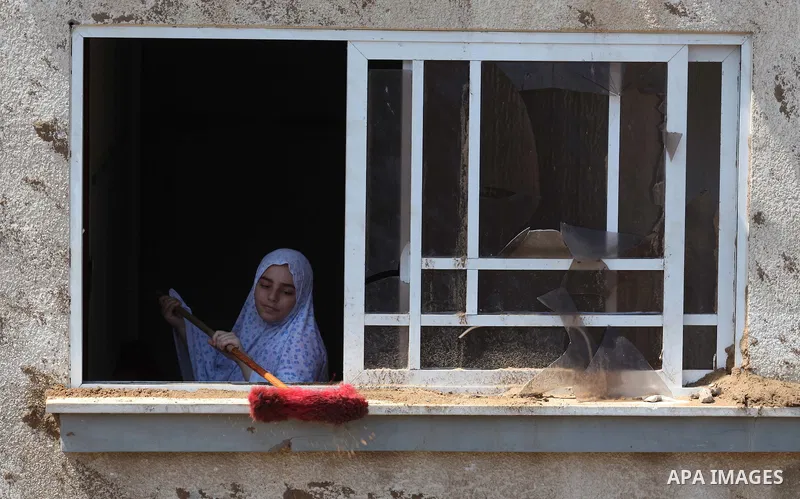 A Palestinian woman cleans the edge of her house's window, which witnesses said was damaged in an Israeli air strike, in Gaza City August 22, 2014. Since the collapse on Tuesday of a 10-day ceasefire, the Israeli militar...
