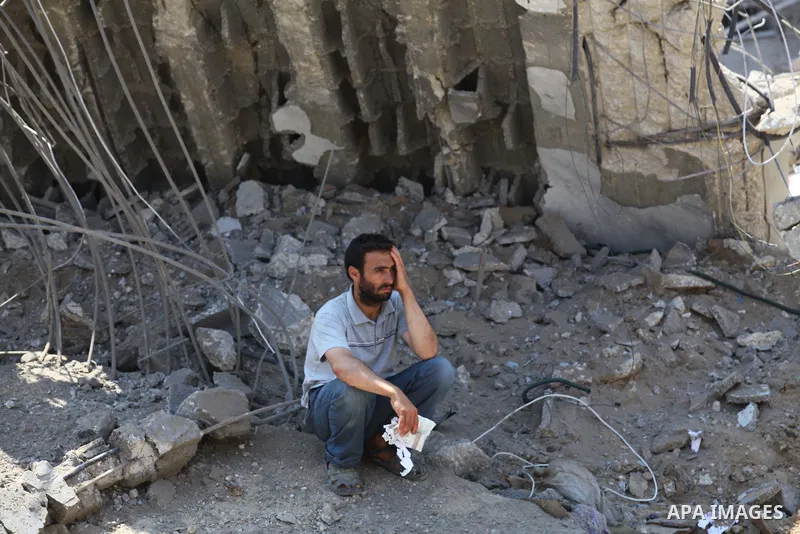 A Palestinian man sits on the remains of a house, which witnesses said was destroyed in an Israeli air strike, in Gaza City August 22, 2014. Since the collapse on Tuesday of a 10-day ceasefire, the Israeli military has r...