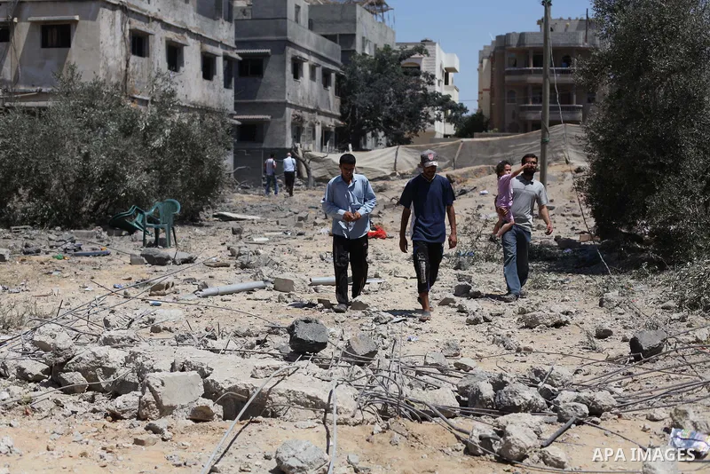 Palestinians gather around the remains of a house, which witnesses said was destroyed in an Israeli air strike, in Gaza City August 22, 2014. Since the collapse on Tuesday of a 10-day ceasefire, the Israeli military has...