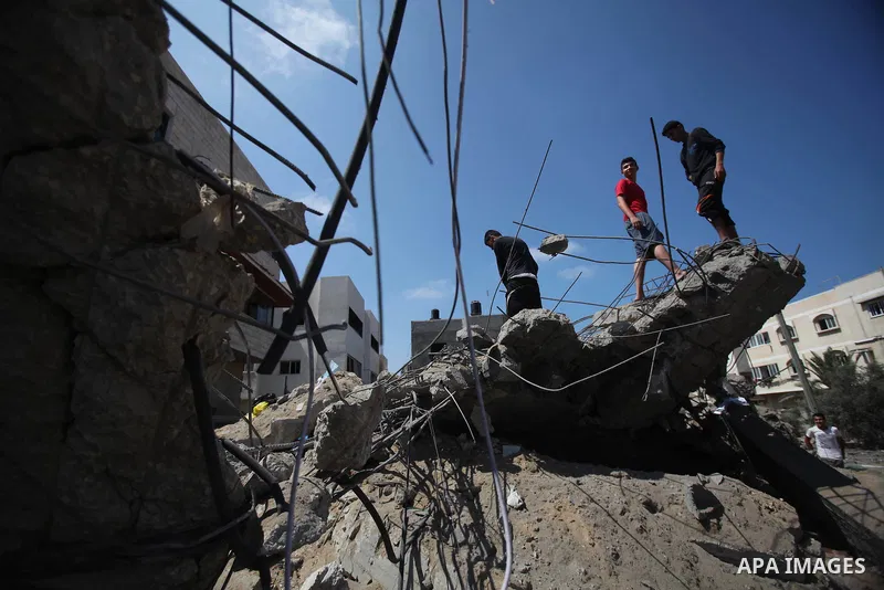 Palestinians gather around the remains of a house, which witnesses said was destroyed in an Israeli air strike, in Gaza City August 22, 2014. Since the collapse on Tuesday of a 10-day ceasefire, the Israeli military has...