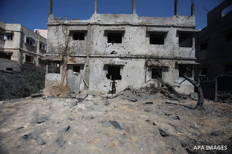 A Palestinian man looks at the remains of a house, which witnesses said was destroyed in an Israeli air strike, in Gaza City August 22, 2014. Since the collapse on Tuesday of a 10-day ceasefire, the Israeli military has...