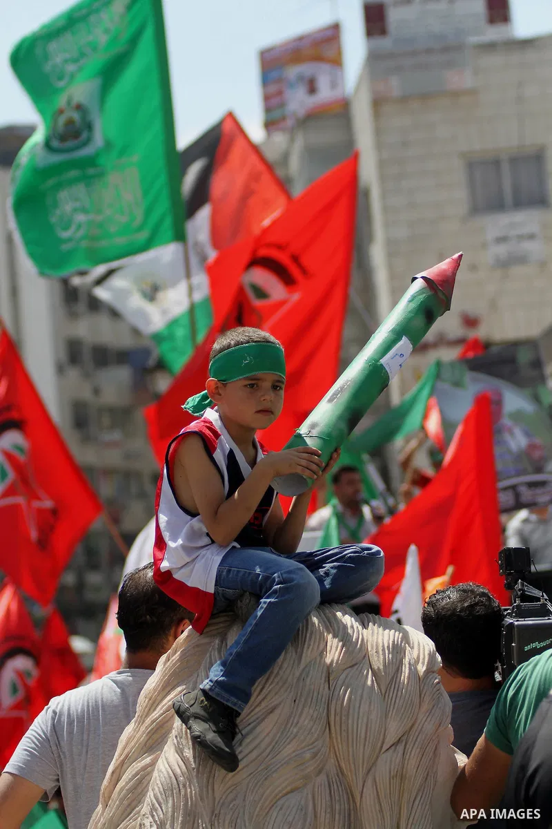 Palestinian protesters wave flags of the Islamist movement Hamas during a demonstration to show support to its militants in the Gaza Strip on August 22, 2014 in the West Bank city of Ramallah. Hostilities in the six-week...