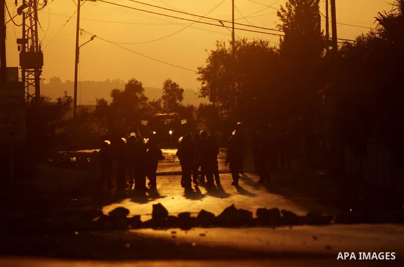 Members of the Israeli security forces stand guard during clashes with Palestinian demonstrators in the West Bank village of Silwad, near Ramallah, following a demonstration in support of the Hamas militants' resistance...