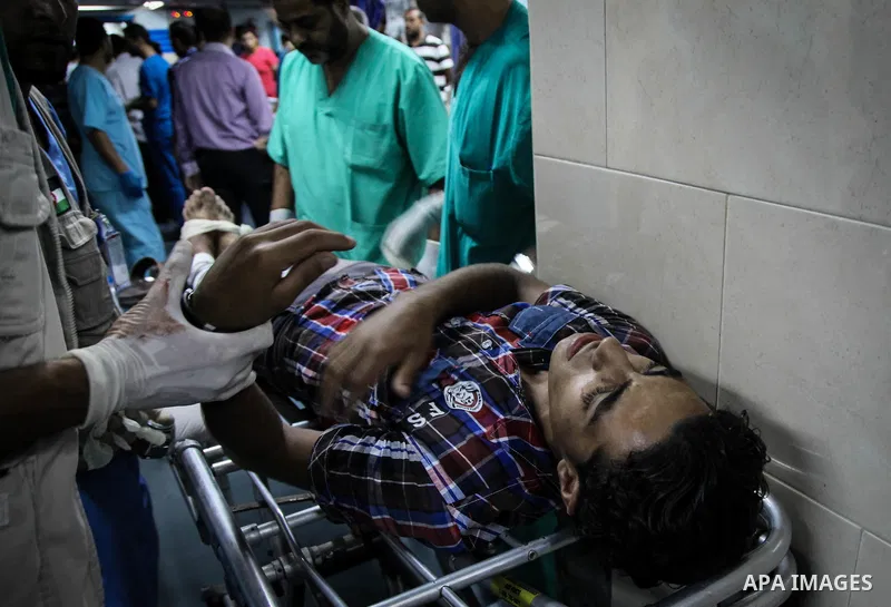 A wounded Palestinian man receives medical treatment in the corridor of the al-Shifa hospital after an Israeli air strike on Gaza City on August 22, 2014. Israeli Prime Minister Benjamin Netanyahu pledged that "Hamas wil...