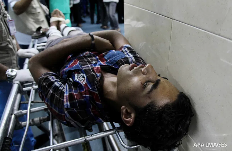 A wounded Palestinian man receives medical treatment in the corridor of the al-Shifa hospital after an Israeli air strike on Gaza City on August 22, 2014. Israeli Prime Minister Benjamin Netanyahu pledged that "Hamas wil...