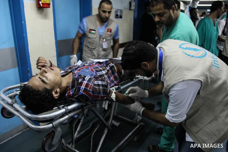 A wounded Palestinian man receives medical treatment in the corridor of the al-Shifa hospital after an Israeli air strike on Gaza City on August 22, 2014. Israeli Prime Minister Benjamin Netanyahu pledged that "Hamas wil...