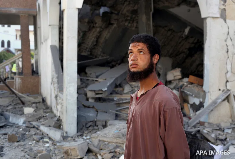 A Palestinian man looks at the remains of a mosque , which witnesses said was destroyed in an Israeli air strike, in Khan Younis in the southern Gaza strip August 23, 2014. Hamas-led gunmen in Gaza executed 18 Palestinia...