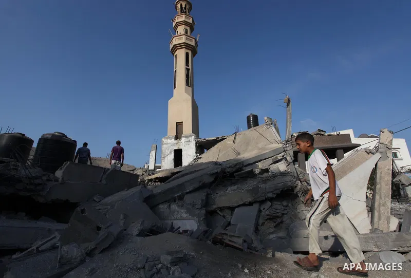 A Palestinian man walks past the remains of a mosque , which witnesses said was destroyed in an Israeli air strike, in Khan Younis in the southern Gaza strip August 23, 2014. Hamas-led gunmen in Gaza executed 18 Palestin...