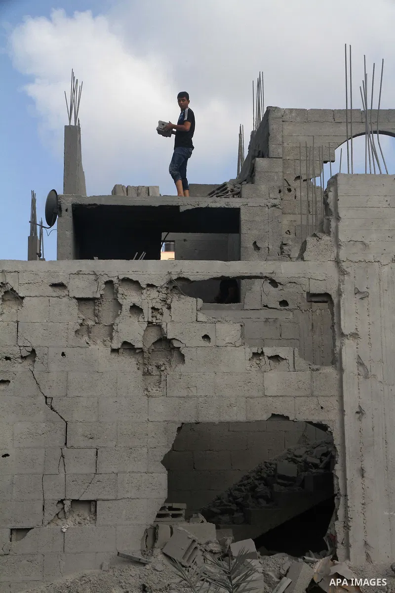Palestinians search for their belongings amid the remains of their house, which witnesses said was destroyed in an Israeli air strike, in Gaza City August 23, 2014. Hamas-led gunmen in Gaza executed 18 Palestinians accus...