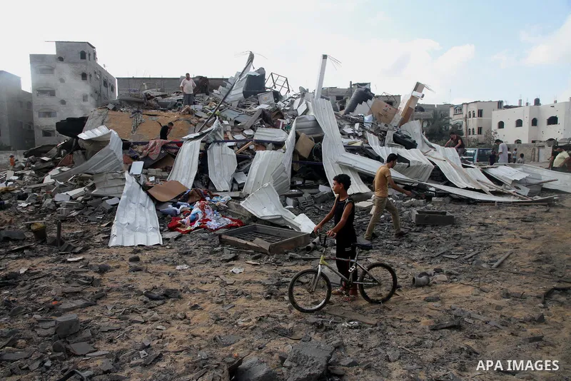 A Palestinian boy looks at the remains a house, which witnesses said was destroyed in an Israeli air strike, in Gaza City August 23, 2014. Hamas-led gunmen in Gaza executed 18 Palestinians accused of collaborating with I...