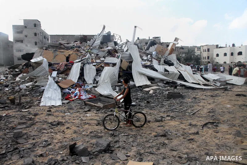 A Palestinian boy looks at the remains a house, which witnesses said was destroyed in an Israeli air strike, in Gaza City August 23, 2014. Hamas-led gunmen in Gaza executed 18 Palestinians accused of collaborating with I...