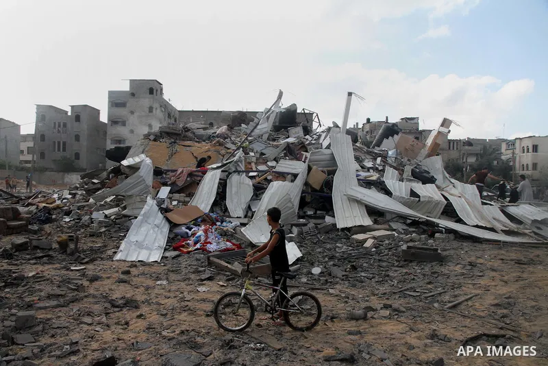 A Palestinian boy looks at the remains a house, which witnesses said was destroyed in an Israeli air strike, in Gaza City August 23, 2014. Hamas-led gunmen in Gaza executed 18 Palestinians accused of collaborating with I...