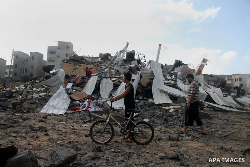A Palestinian boy looks at the remains a house, which witnesses said was destroyed in an Israeli air strike, in Gaza City August 23, 2014. Hamas-led gunmen in Gaza executed 18 Palestinians accused of collaborating with I...