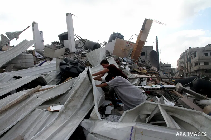 Palestinians search for their belongings amid the remains of their house, which witnesses said was destroyed in an Israeli air strike, in Gaza City August 23, 2014. Hamas-led gunmen in Gaza executed 18 Palestinians accus...