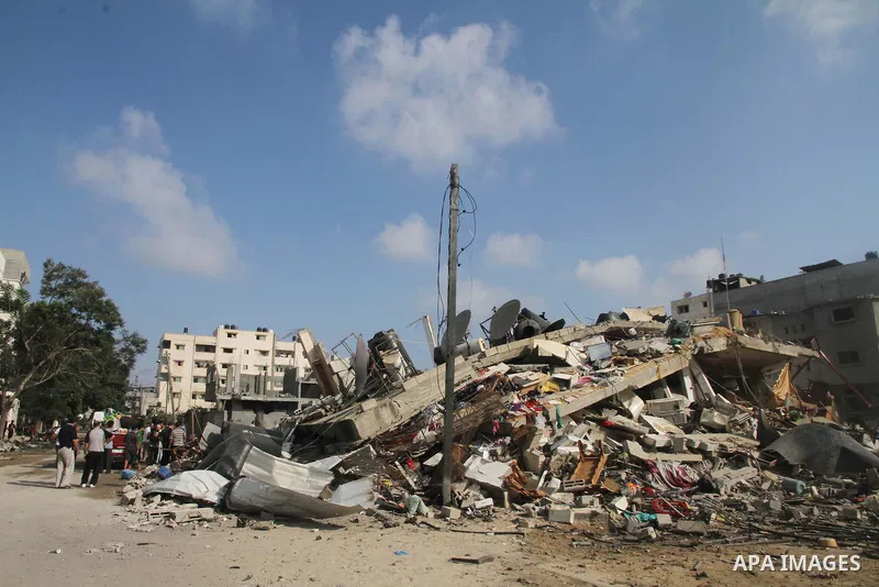 Palestinians gather around the remains of a house, which witnesses said was destroyed in an Israeli air strike, in Gaza City August 23, 2014. Hamas-led gunmen in Gaza executed 18 Palestinians accused of collaborating wit...