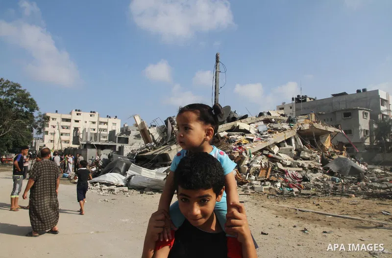 Palestinians gather around the remains of a house, which witnesses said was destroyed in an Israeli air strike, in Gaza City August 23, 2014. Hamas-led gunmen in Gaza executed 18 Palestinians accused of collaborating wit...
