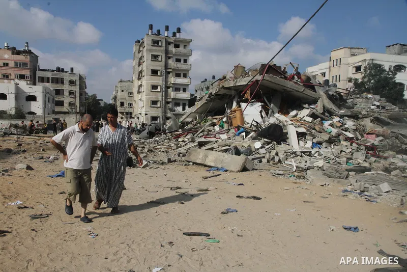 Palestinians gather around the remains of a house, which witnesses said was destroyed in an Israeli air strike, in Gaza City August 23, 2014. Hamas-led gunmen in Gaza executed 18 Palestinians accused of collaborating wit...
