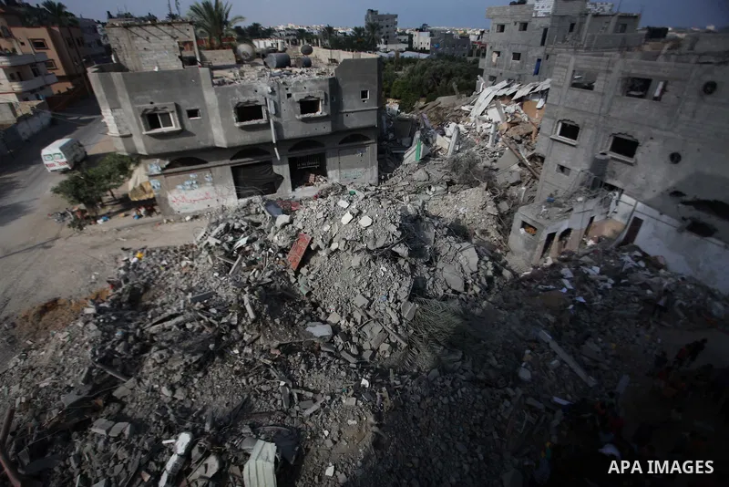 Palestinian men inspect their damaged house as the remains of another a house, which witnesses said was destroyed by an Israeli air strike, are seen in the central Gaza Strip August 23, 2014. Israeli aircraft bombed the...