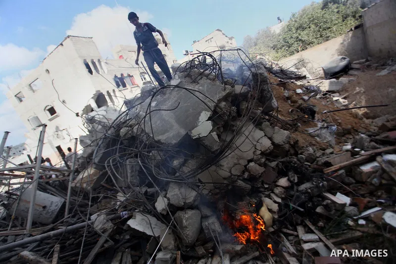 A Palestinian man inspects his damaged house as the remains of another a house, which witnesses said was destroyed by an Israeli air strike, are seen in the central Gaza Strip August 23, 2014. Israeli aircraft bombed the...