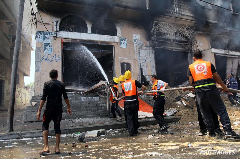 Palestinian firefighters participate in efforts to put out a fire at the scene of what witnesses said was an Israeli air strike on a house in Gaza City August 23, 2014. Israeli aircraft bombed the Gaza Strip on Saturday...