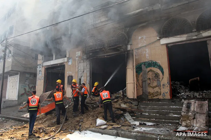 Palestinian firefighters participate in efforts to put out a fire at the scene of what witnesses said was an Israeli air strike on a house in Gaza City August 23, 2014. Israeli aircraft bombed the Gaza Strip on Saturday...