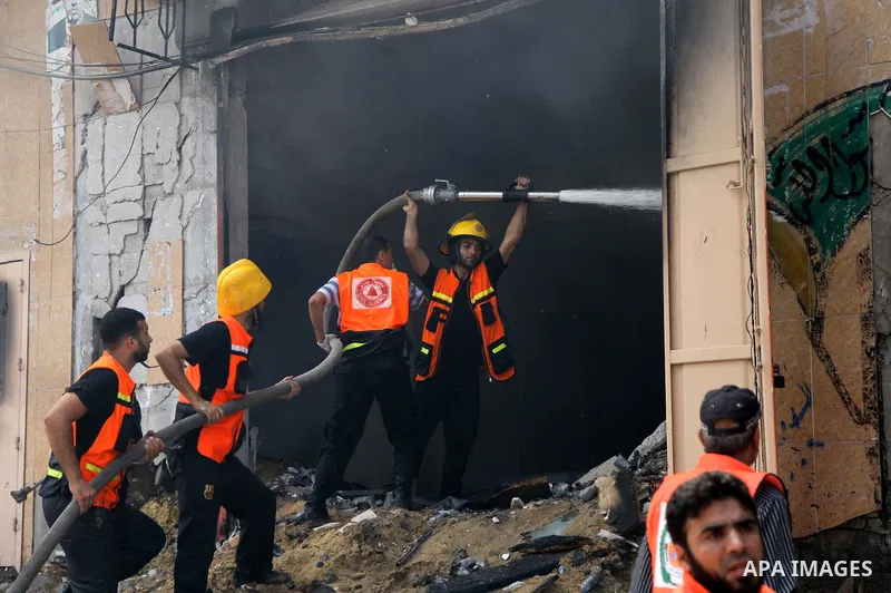 Palestinian firefighters participate in efforts to put out a fire at the scene of what witnesses said was an Israeli air strike on a house in Gaza City August 23, 2014. Israeli aircraft bombed the Gaza Strip on Saturday...