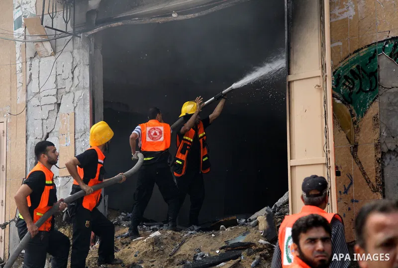 Palestinian firefighters participate in efforts to put out a fire at the scene of what witnesses said was an Israeli air strike on a house in Gaza City August 23, 2014. Israeli aircraft bombed the Gaza Strip on Saturday...
