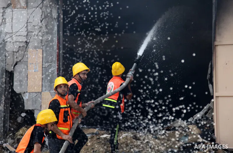 Palestinian firefighters participate in efforts to put out a fire at the scene of what witnesses said was an Israeli air strike on a house in Gaza City August 23, 2014. Israeli aircraft bombed the Gaza Strip on Saturday...