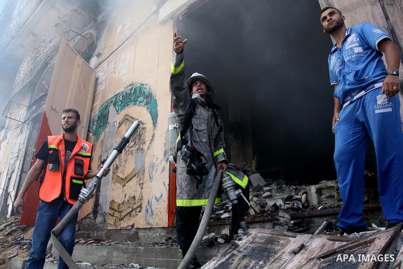 Palestinian firefighters participate in efforts to put out a fire at the scene of what witnesses said was an Israeli air strike on a house in Gaza City August 23, 2014. Israeli aircraft bombed the Gaza Strip on Saturday...