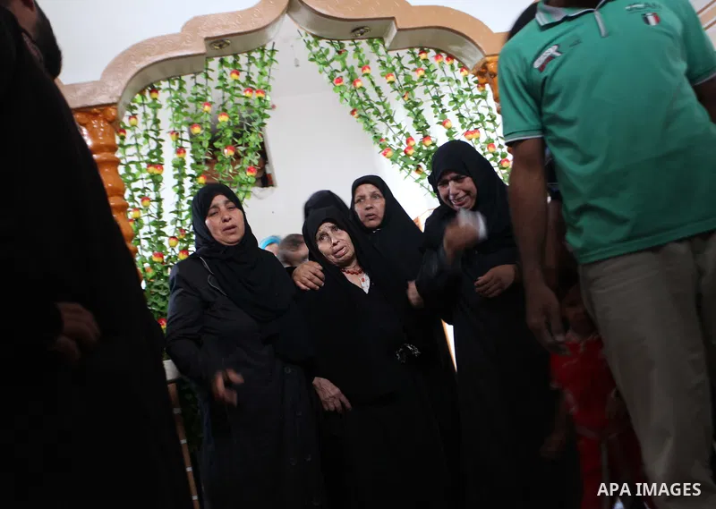 Relatives of five Palestinians from the Abu Dahroj family, whom medics said were killed in an Israeli air strike, mourn as they gather around the remains of some of their bodies during their funeral in the central Gaza S...