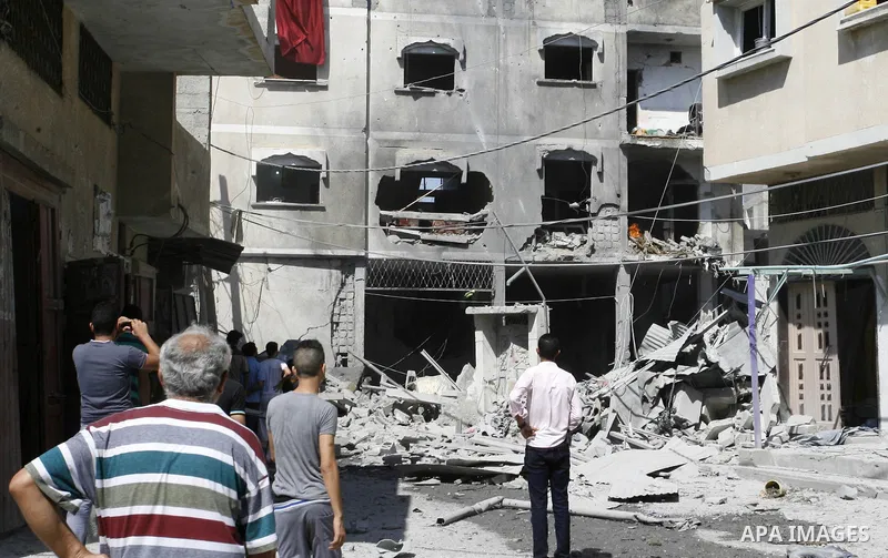 Palestinian men look at the shattered home after Israeli air strike in Rafah in the southern Gaza Strip on August 23, 2014. Israel kept up the pressure on Hamas in Gaza, carrying out multiple air strikes that killed six...