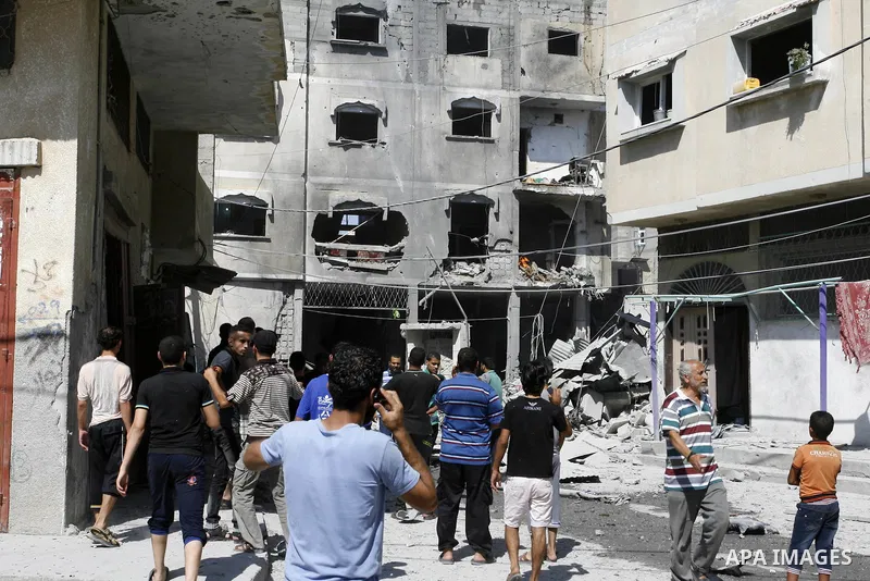 Palestinian men look at the shattered home after Israeli air strike in Rafah in the southern Gaza Strip on August 23, 2014. Israel kept up the pressure on Hamas in Gaza, carrying out multiple air strikes that killed six...