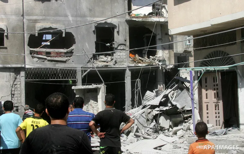 Palestinian men look at the shattered home after Israeli air strike in Rafah in the southern Gaza Strip on August 23, 2014. Israel kept up the pressure on Hamas in Gaza, carrying out multiple air strikes that killed six...