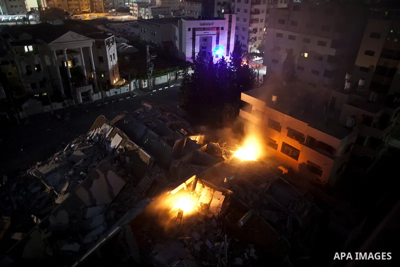 Palestinians walk next to a building that was destroyed by an Israeli air strike in Gaza City on August 23, 2014. Israel said it had carried out 55 air strikes over the Gaza Strip on August 23 and that around 45 rockets...