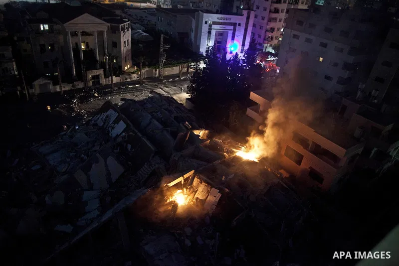 Palestinians walk next to a building that was destroyed by an Israeli air strike in Gaza City on August 23, 2014. Israel said it had carried out 55 air strikes over the Gaza Strip on August 23 and that around 45 rockets...